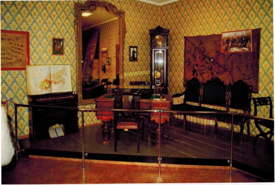 Уголок экспозиции музея: клавикорды, зеркало, напольные часы, стол, гобелен - 1890-е годы